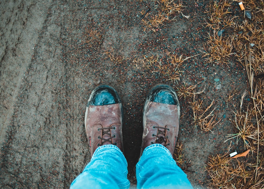 person in blue denim jeans and brown leather shoes