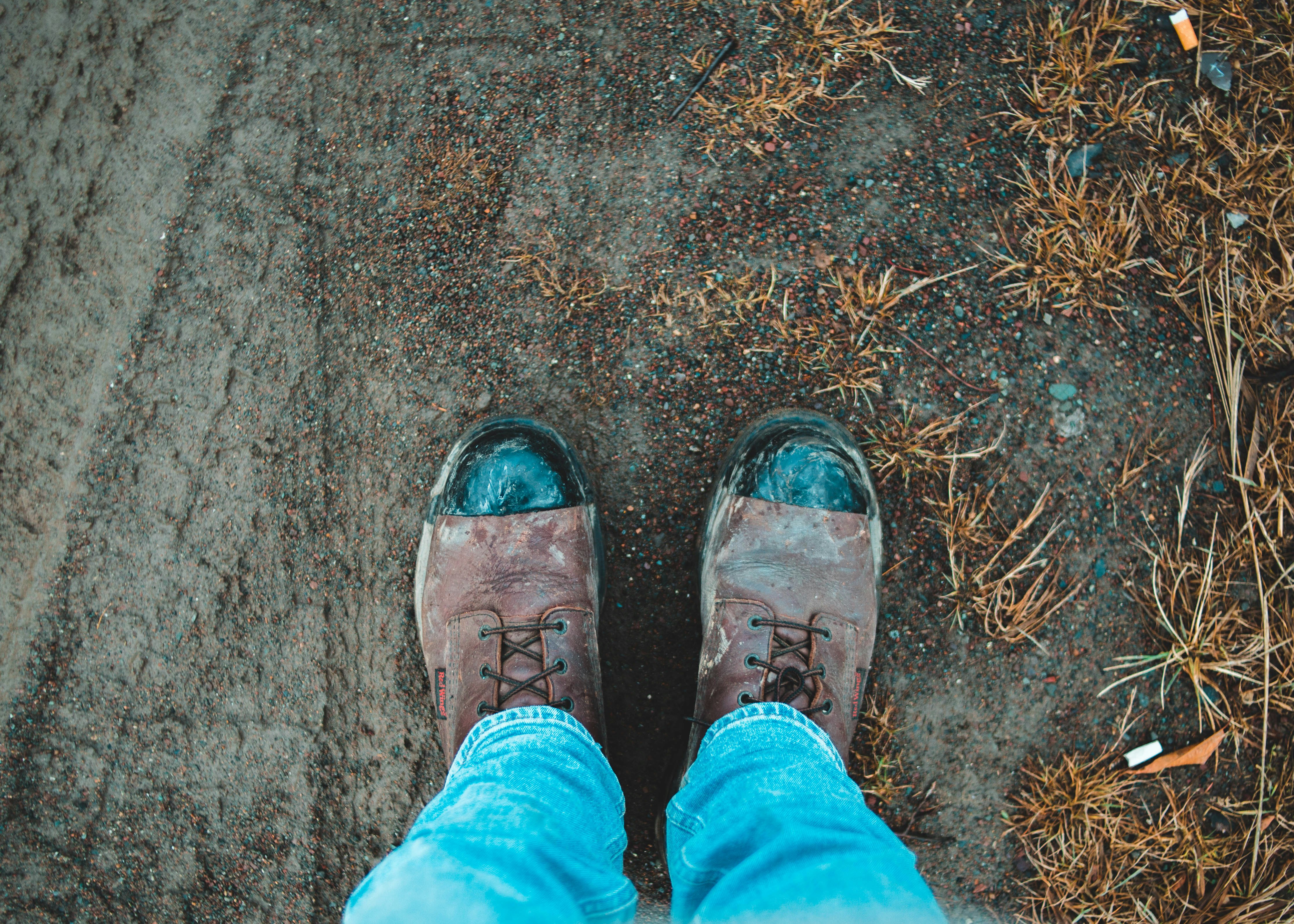 person in blue denim jeans and brown leather shoes