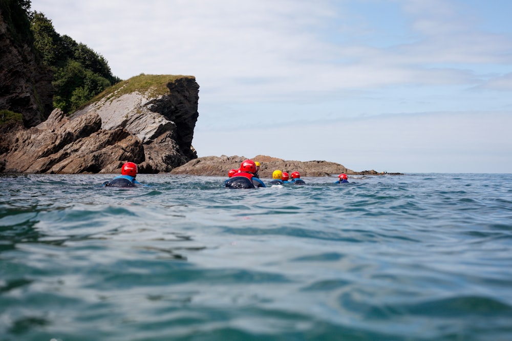 people swimming on sea during daytime