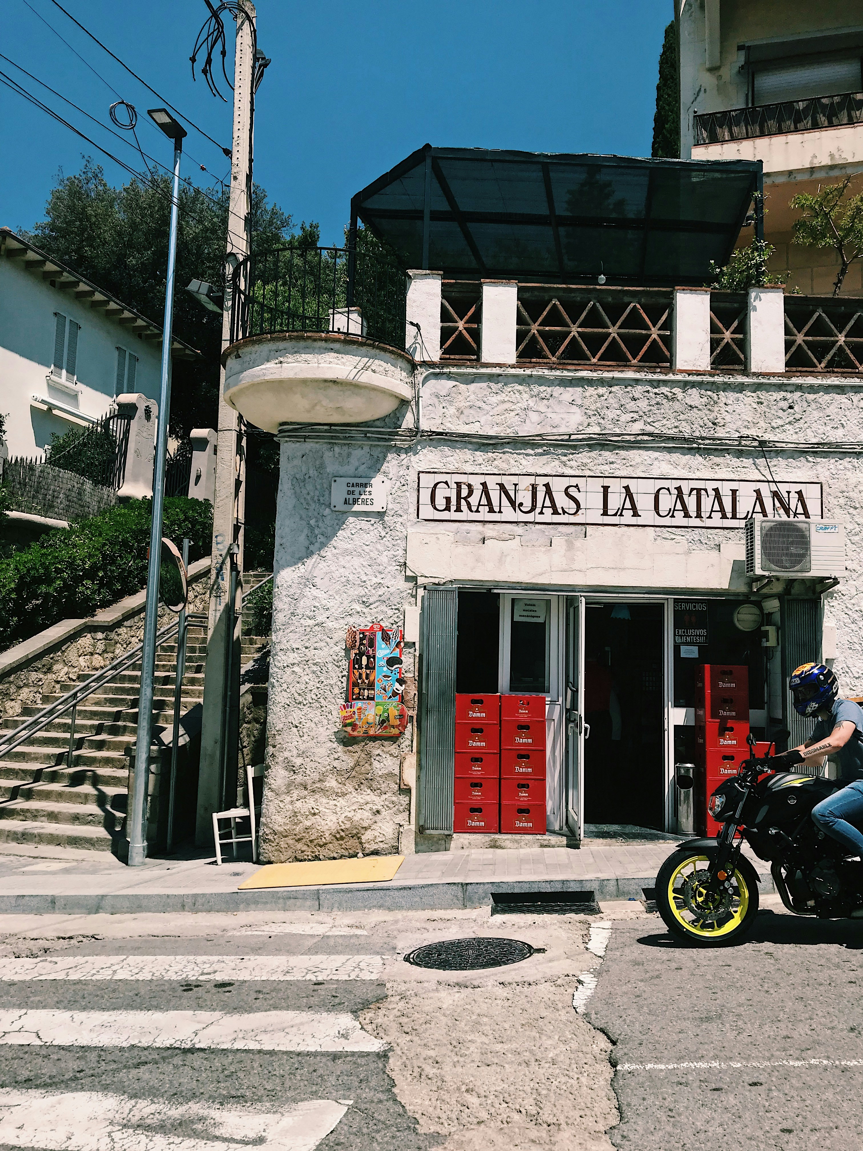 black motorcycle parked beside gray concrete building during daytime