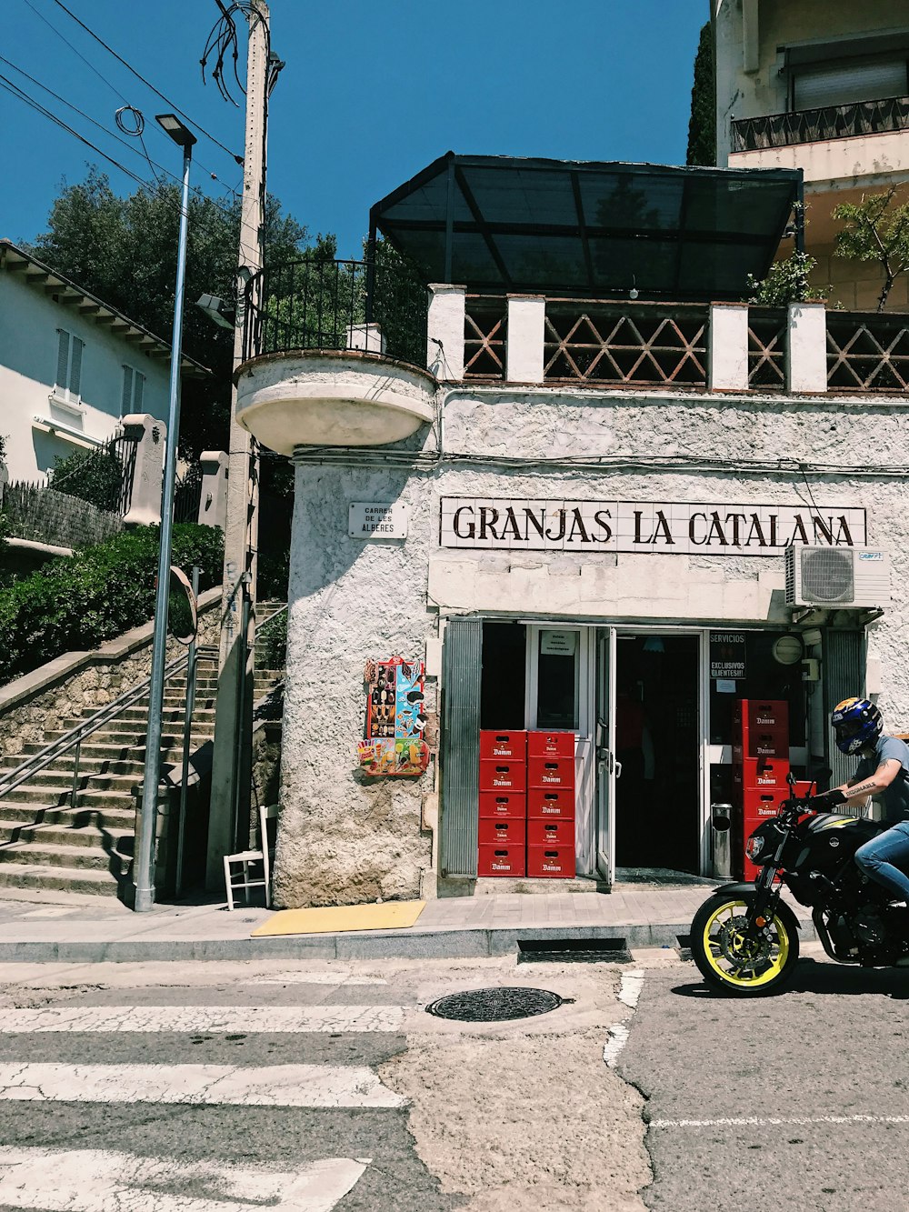 black motorcycle parked beside gray concrete building during daytime