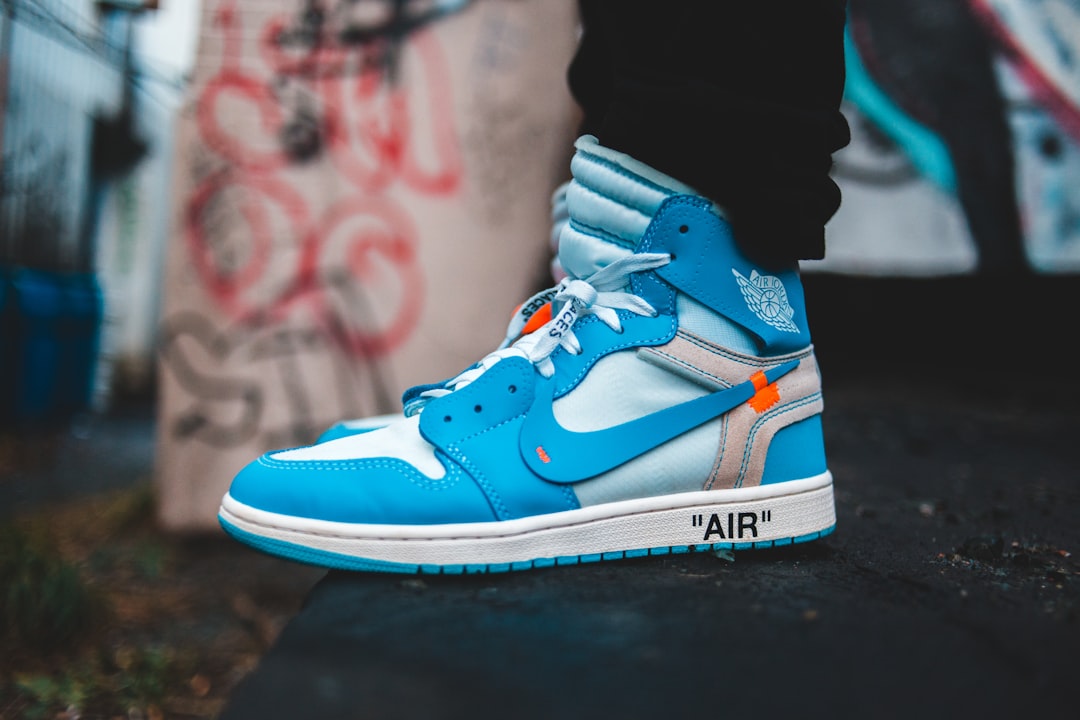 person wearing white and blue nike air jordan 1 shoes