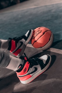 person wearing black and red nike basketball shoes