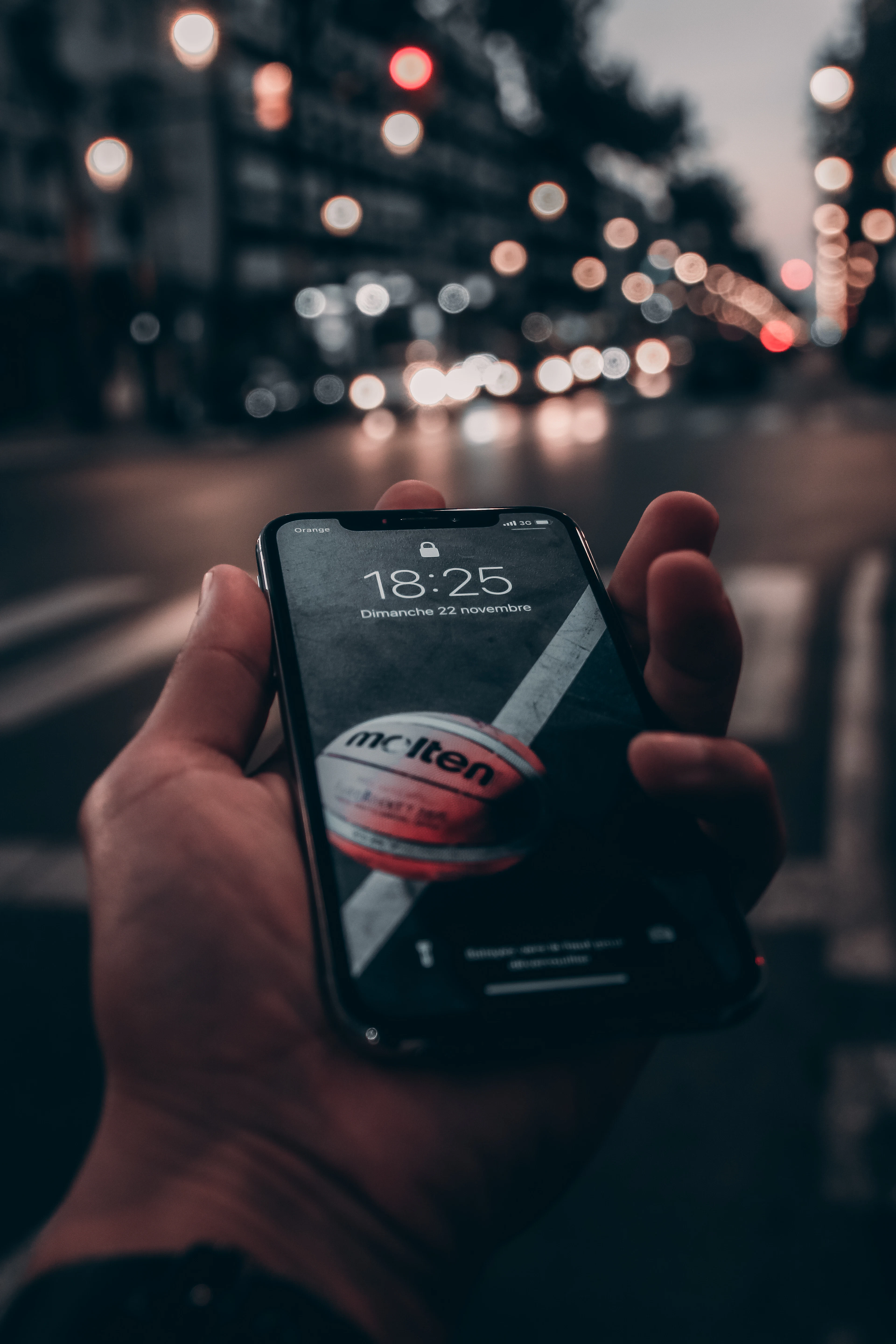 A close-up of a person's hand holding a black smartphone