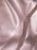 Soft, flowing fabric with a smooth, shiny texture featuring gentle folds and a subtle sheen, creating an elegant and luxurious appearance.