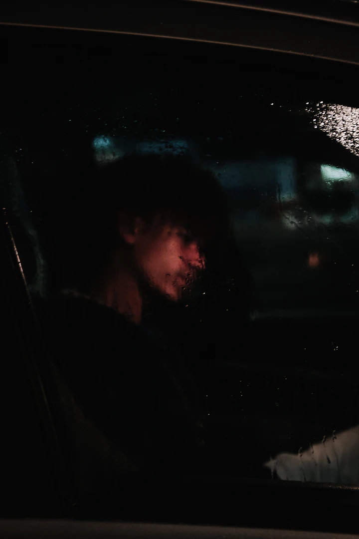 Man sitting in a car at night