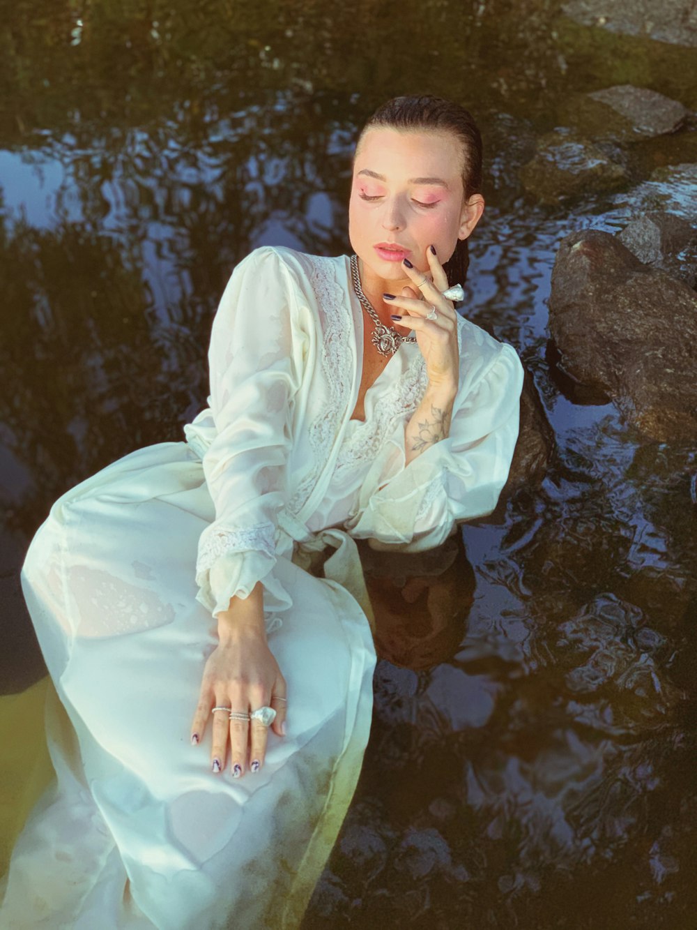 woman in white long sleeve dress sitting on rock