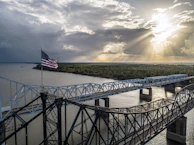 us a flag on bridge under cloudy sky during daytime