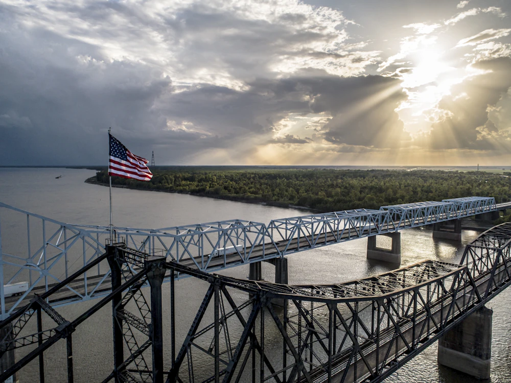 American flag on a bridge under a cloudy sky