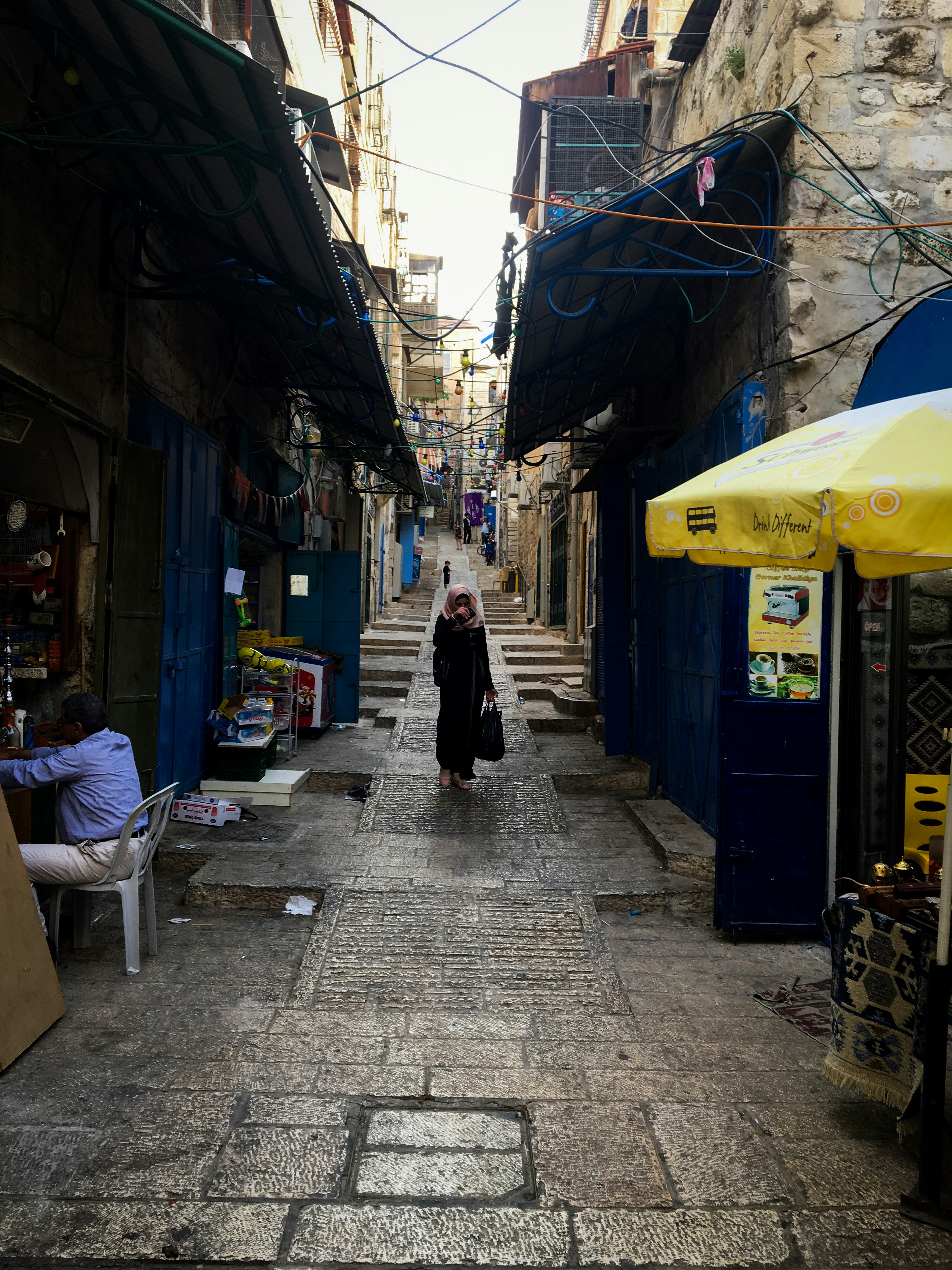 woman in black jacket walking on sidewalk during daytime