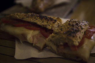 Quesocaliente sandwich melting cheese perfectly with fresh tomato and lettuce.