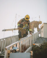 Firefighter team coordinating to carry a rescue dummy across an obstacle.