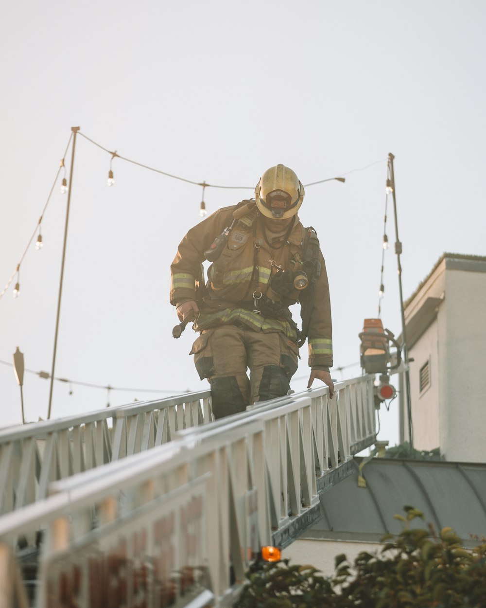 man in brown and green camouflage jacket and pants standing on white bridge during daytime