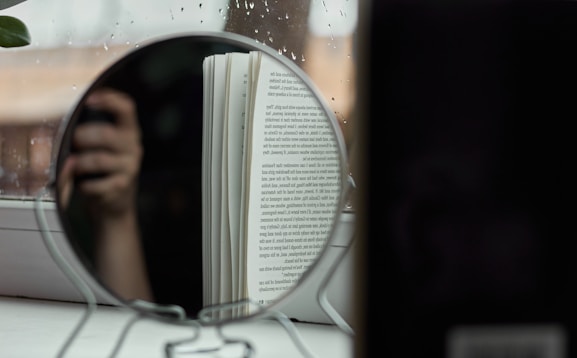 woman in white and black stripe shirt holding book