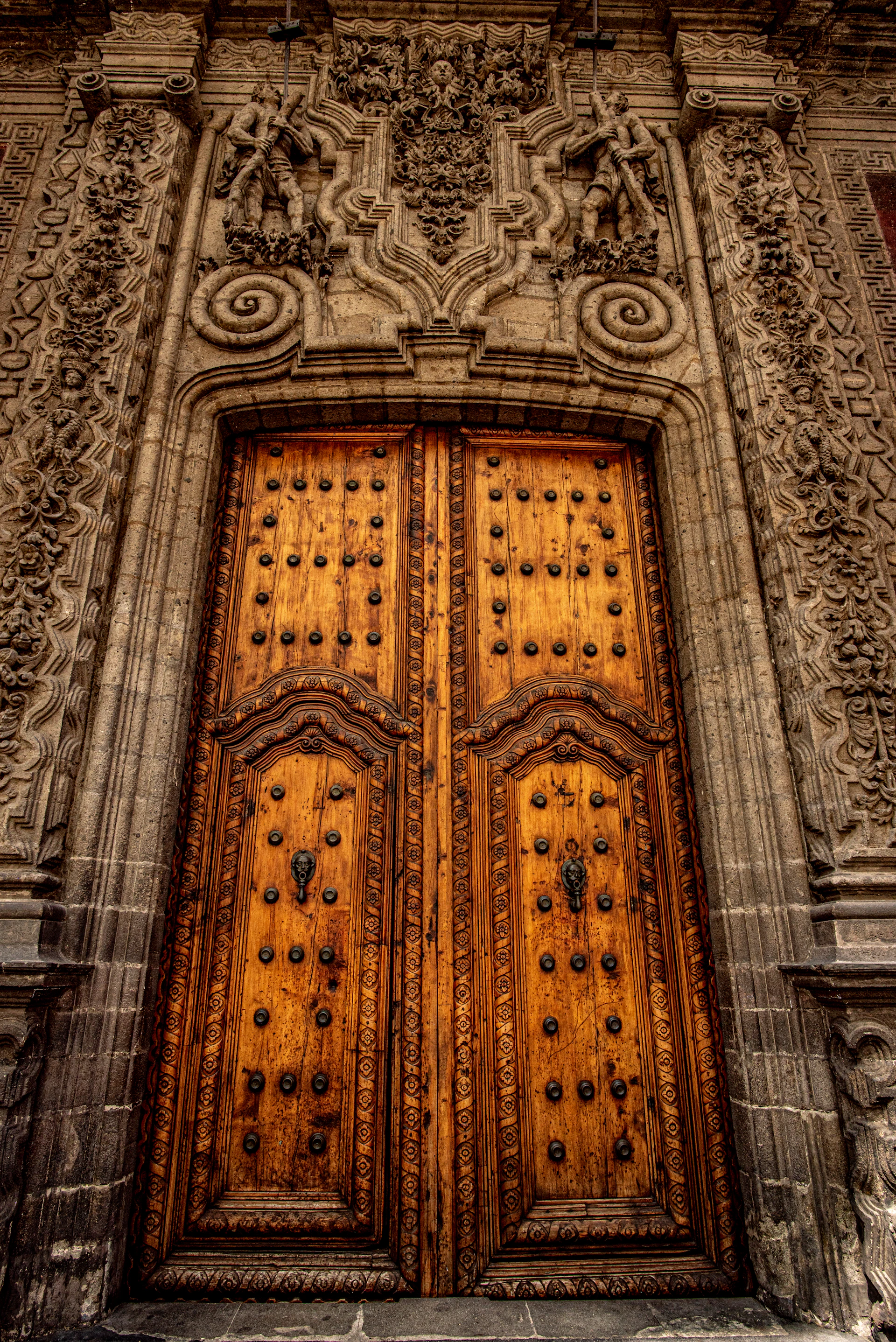 A beautifully crafted wooden door with intricate details, set in a warm, elegant interior reflecting the craftsmanship of Joharat Al Khshab.