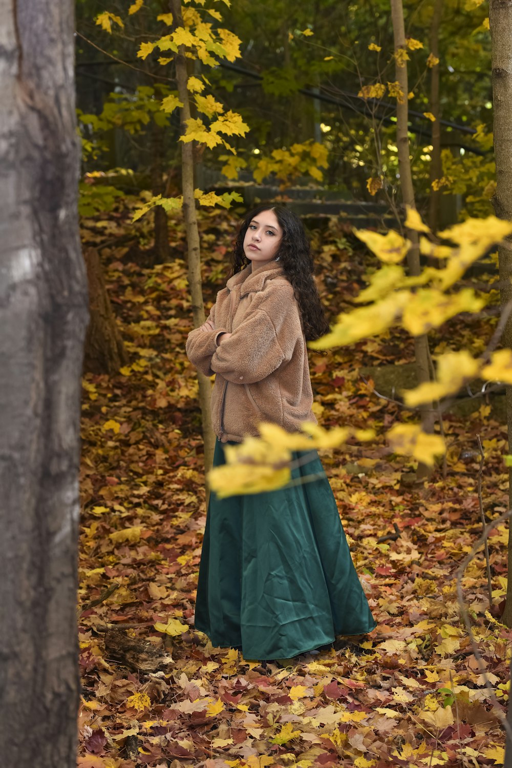 woman in brown coat standing near brown tree during daytime