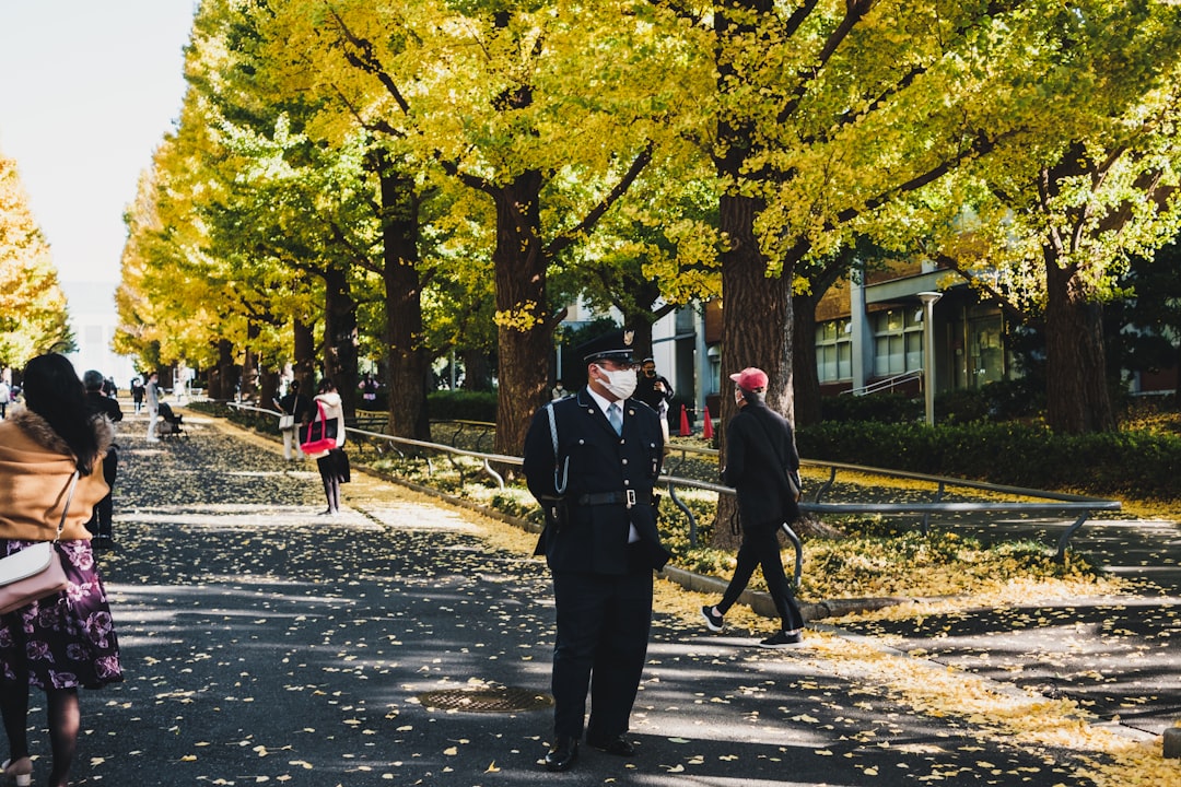 man in black coat walking on sidewalk during daytime