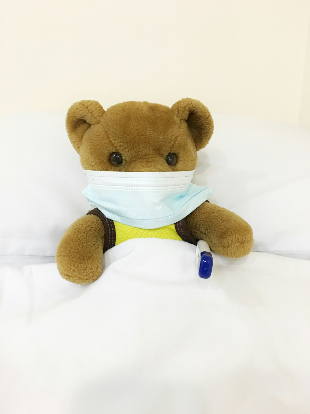 brown bear plush toy on white textile