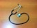 A stethoscope with dark tubing and a metal chest piece is placed on a wooden surface.