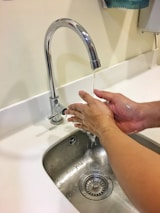 Sparklehaven technician carefully sanitizing a sparkling bathroom sink with eco-safe supplies.