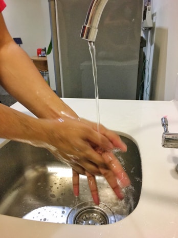 A family happily using handwash in a bright bathroom setting.