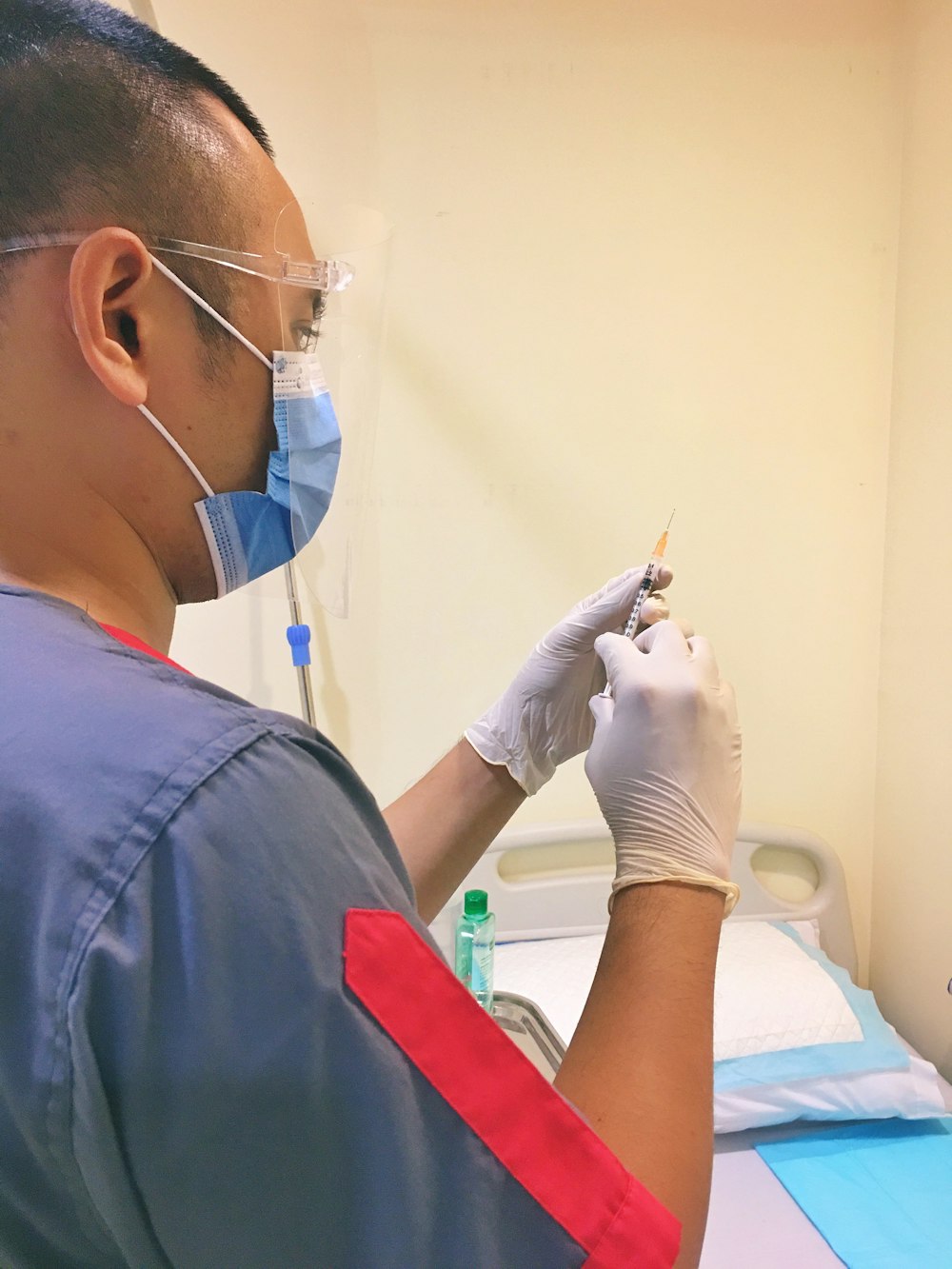 man in blue scrub suit holding blue pen