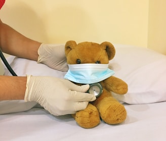 brown bear plush toy on white bed