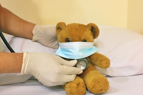 brown bear plush toy on white bed