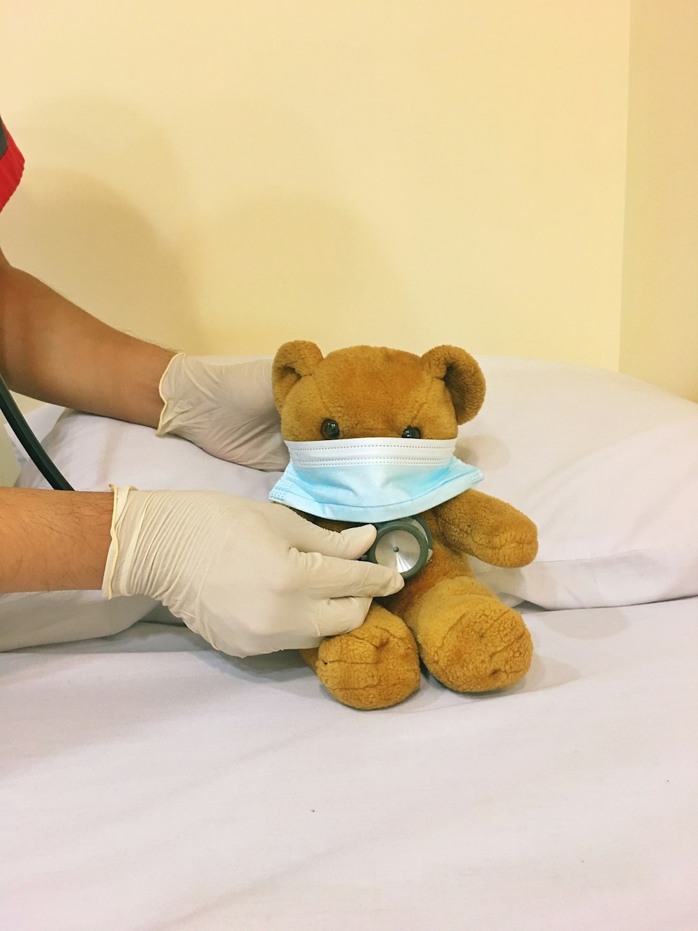 Juguete de peluche de oso pardo en cama blanca