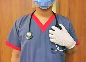 woman in blue scrub suit wearing white mask