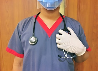 woman in blue scrub suit wearing white mask