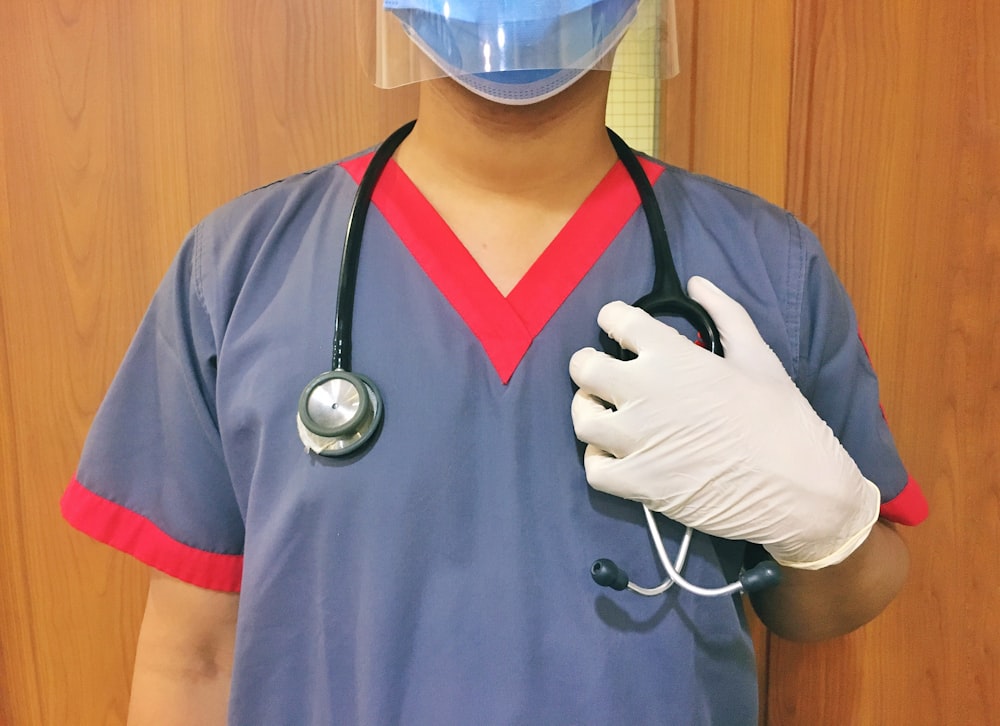 woman in blue scrub suit wearing white mask