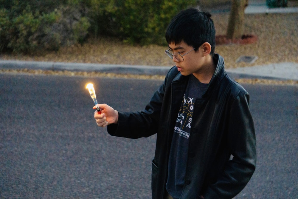 man in black jacket holding lighted sparkler
