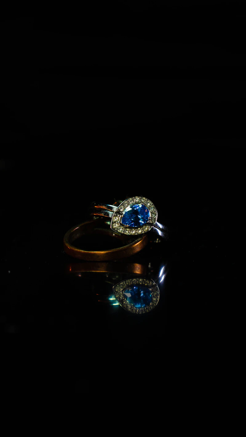 Sapphire and diamond ring glowing against a black background