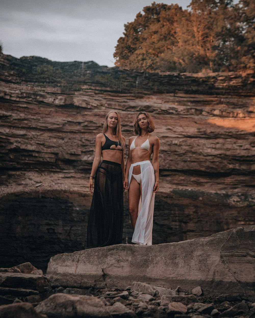 2 women in white dress standing on rock formation during daytime