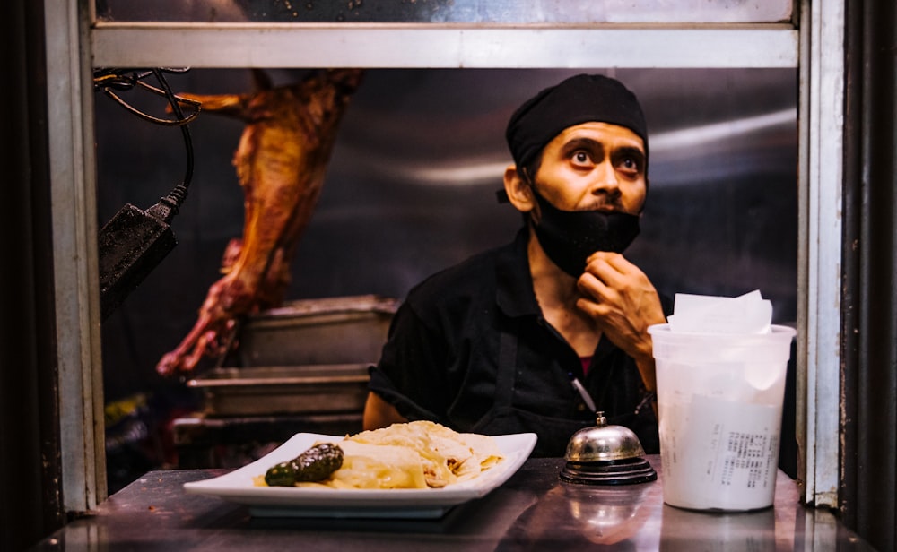 woman in black hijab holding fork and bread knife