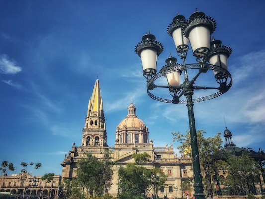 Black street light near brown concrete building during daytime — Guadalajara, Mexico