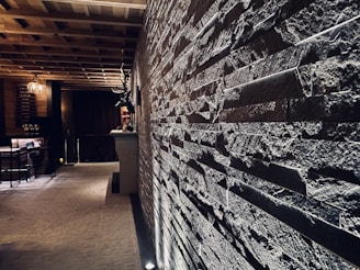 Elegant restaurant interior featuring stone walls and soft, golden lighting.