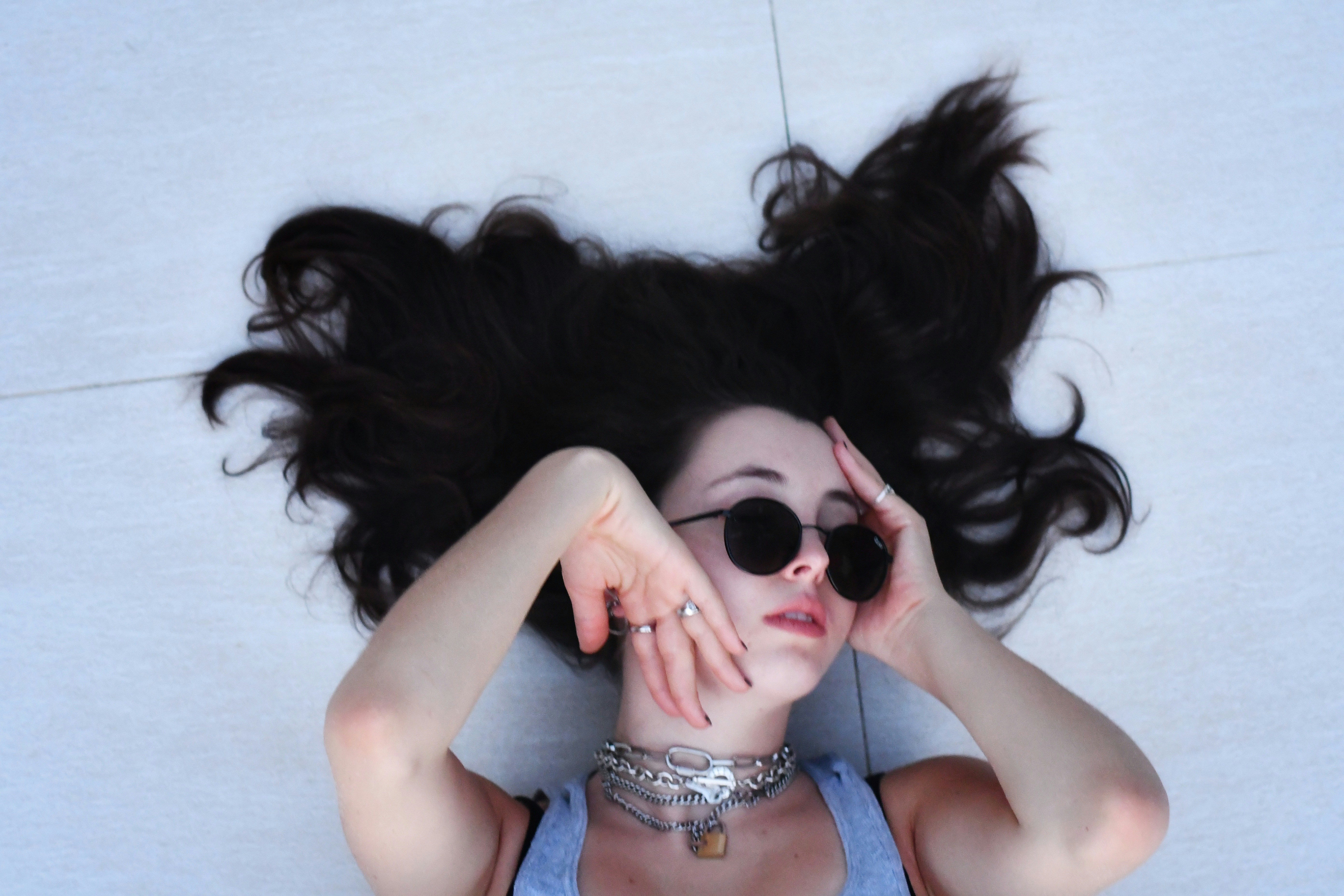 A girl laying on the ground with wavy hair.