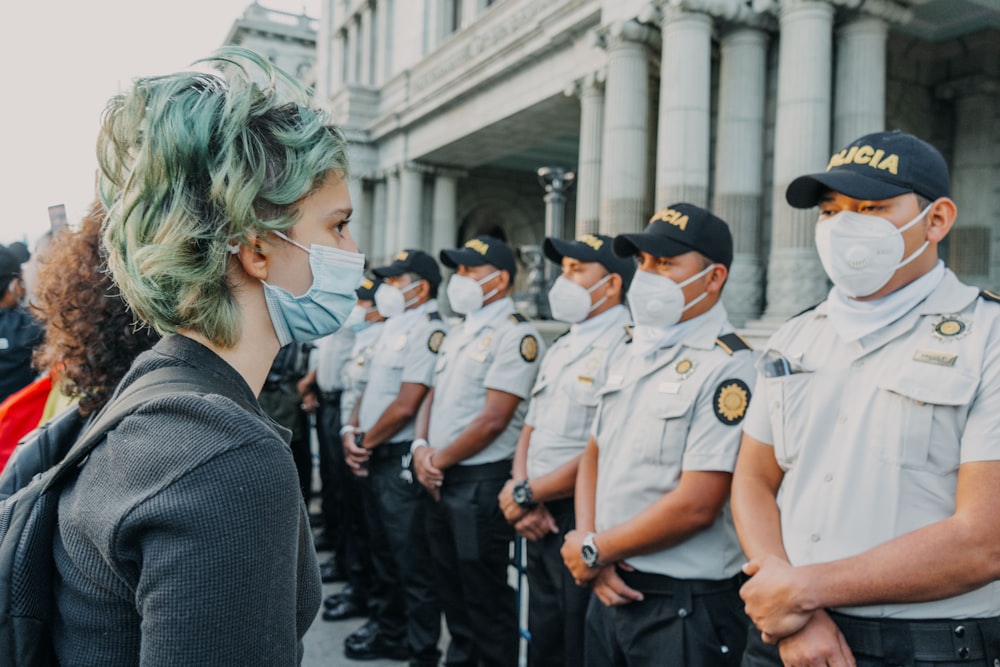 people in uniform standing on street during daytime