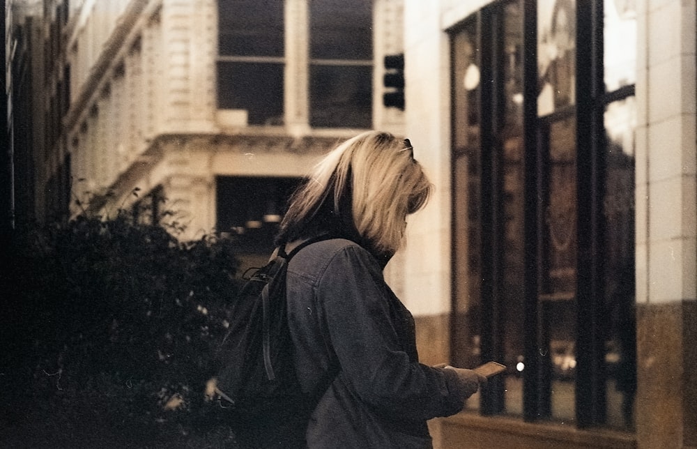 woman in black coat standing near brown wooden door