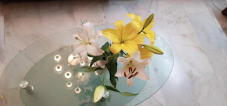 Luxurious white lilies arranged with gold accent details on a marble countertop.