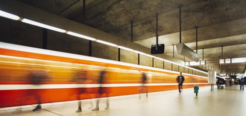 A busy Madrid metro station with people boarding trains during rush hour.