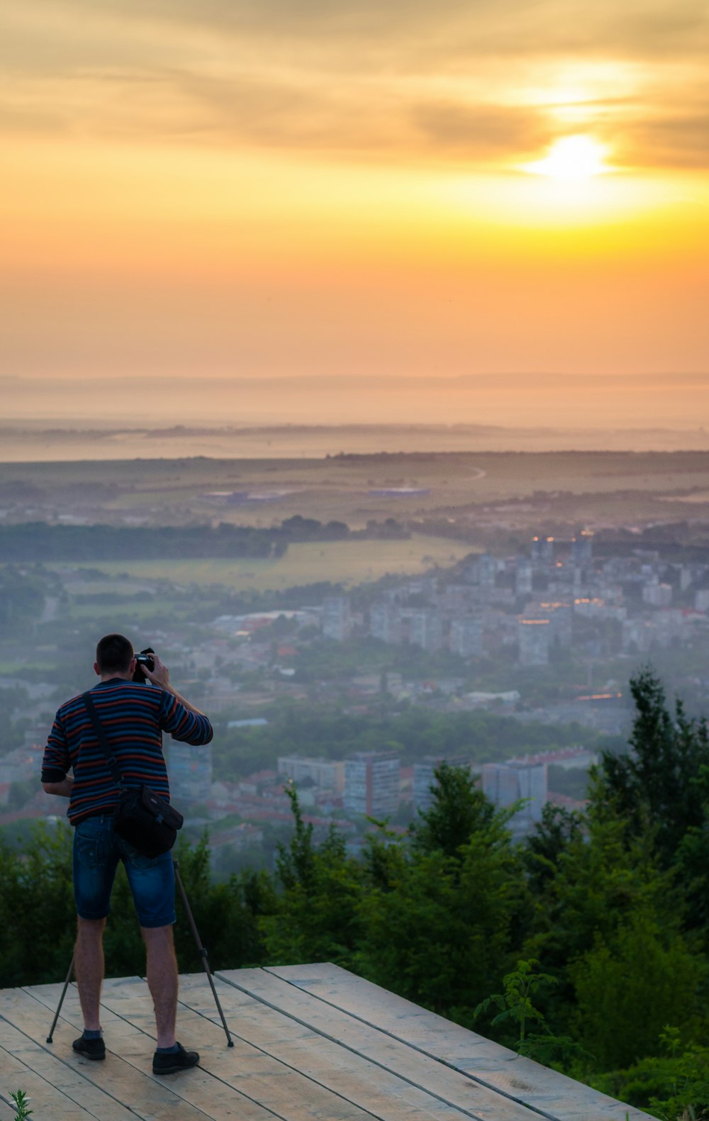 man in black and white striped long sleeve shirt standing on top of mountain during daytime