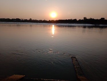 A tranquil scene of a sunset over a calm river, symbolizing peace.