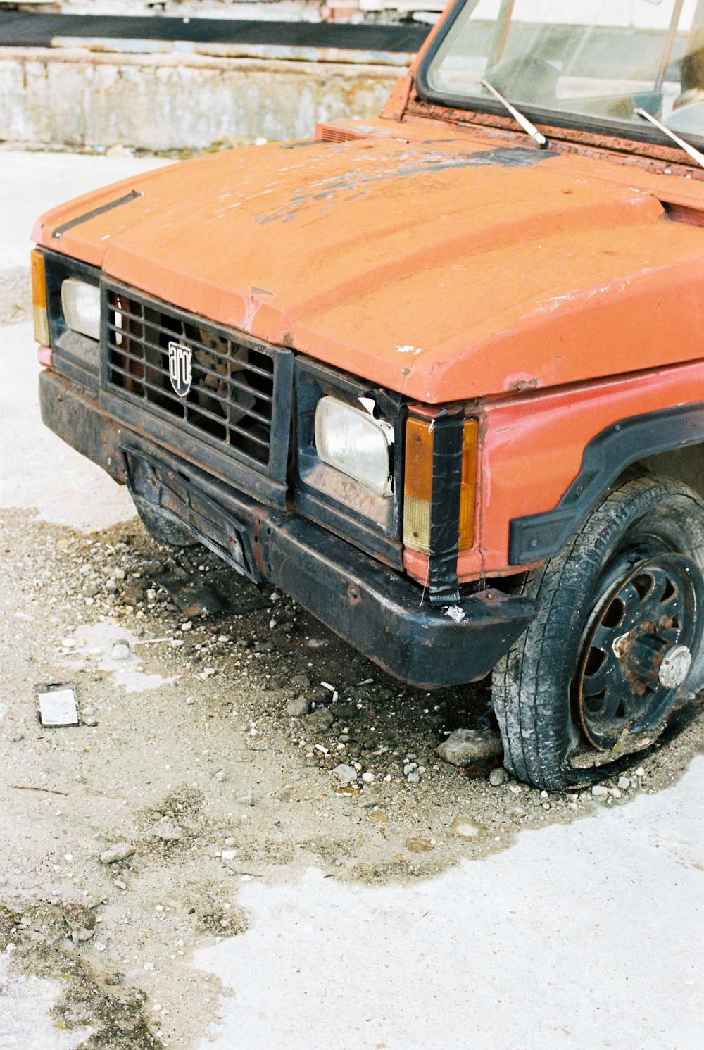 orange car on gray dirt ground