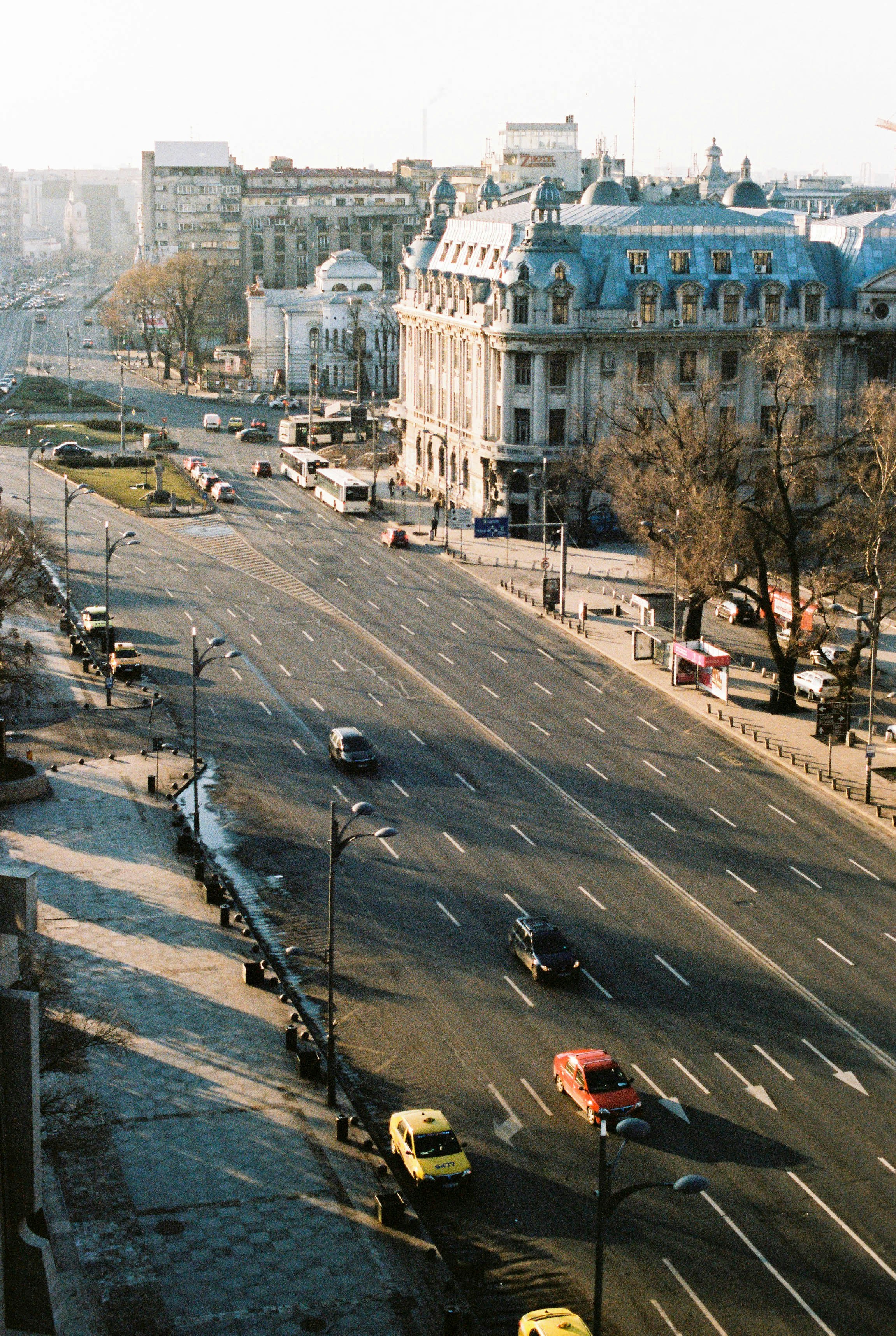 cars parked on parking lot near white concrete building during daytime