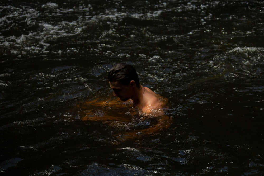 topless man in water during daytime