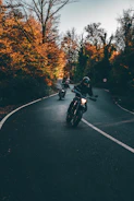 Bikers riding off-road trails surrounded by autumn-colored forests near Saluzzo.