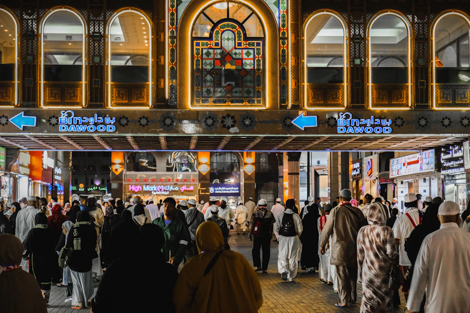 A vibrant marketplace scene in the UAE with diverse products and happy customers browsing online on various devices.